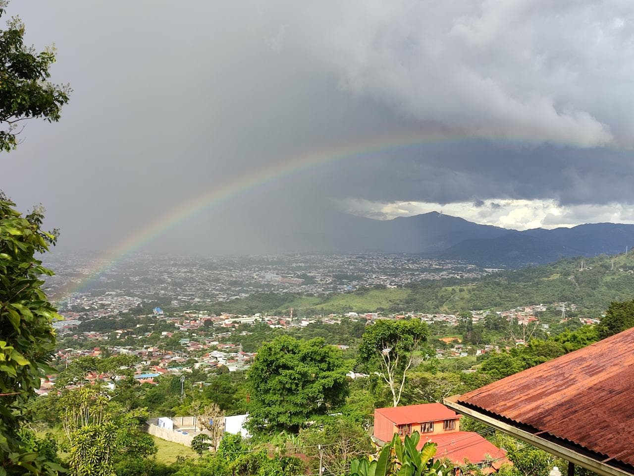 A rainbow over Alajuelita and the San José valley after the rain, seen from the hills