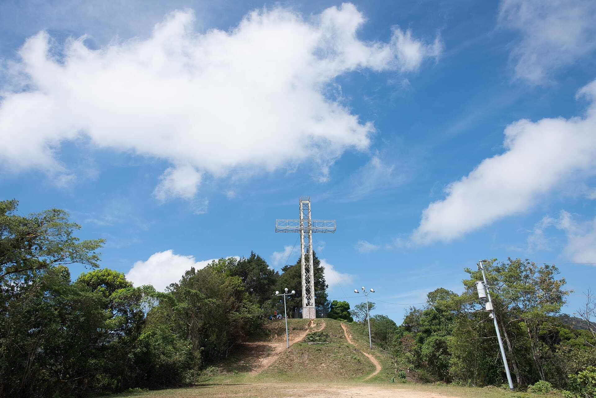 The iron Cruz de Alajuelita on top of Cerro San Miguel under a blue sky